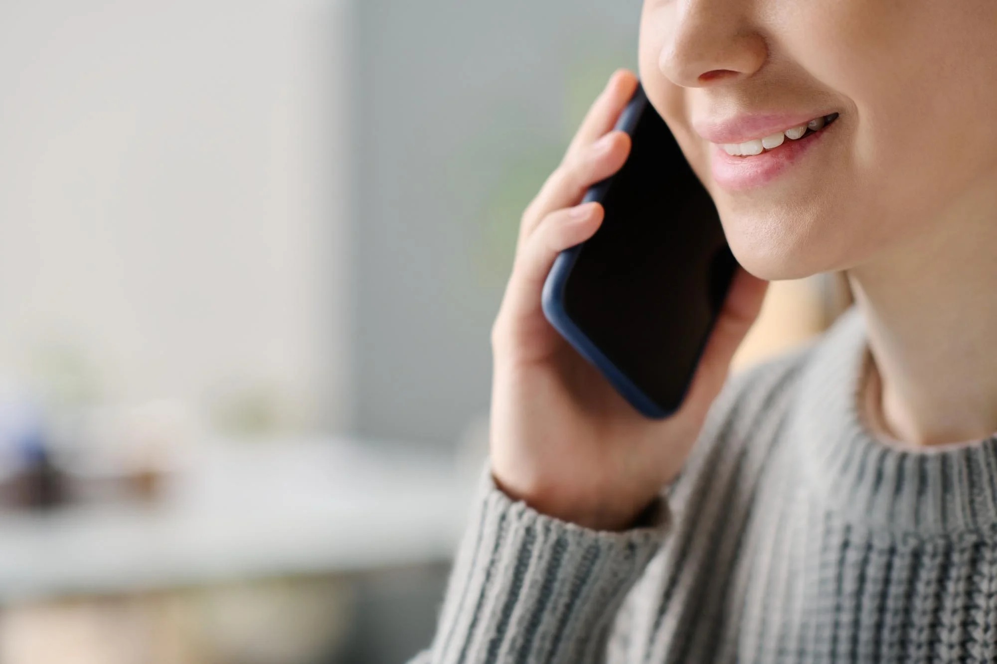 Personne souriante au téléphone pour demander un devis